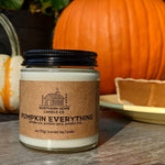 4 ounce soy candle that reads northern home candle and pumpkin everything. 2 pumkins are in the background as well as pumpkin pie. 