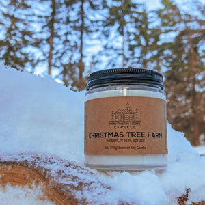 
                  
                    Load image into Gallery viewer, Soy candle with brown label that reads northern home candle company and Christmas Tree Farm. Balsam, fraser, spruce soy candle on a snowy log with trees in the background.
                  
                